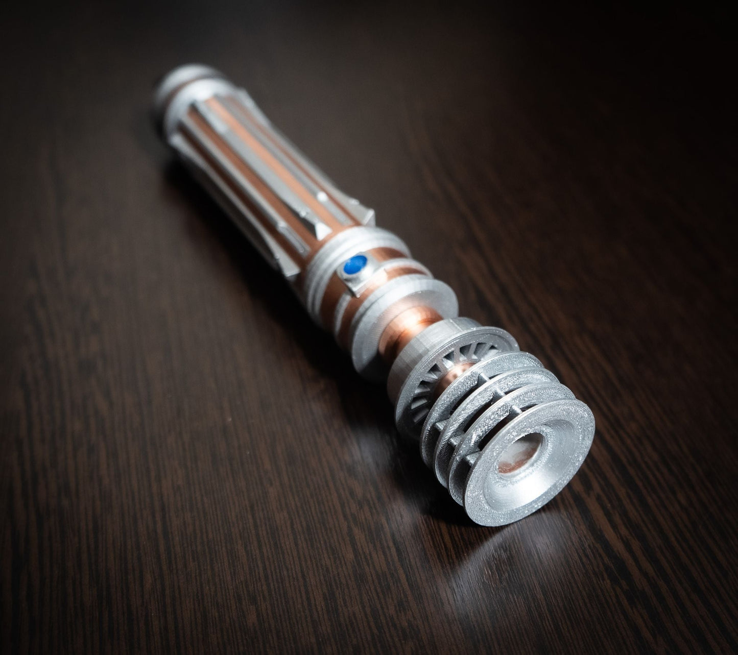 Star Wars inspired Leia lightsaber bridal bouquet holder in chrome and copper finish on dark wooden surface