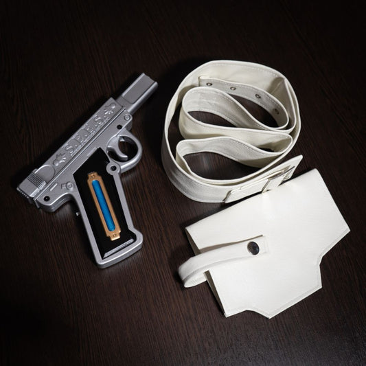 Silver gun-shaped object with a white belt and pouch on a dark surface