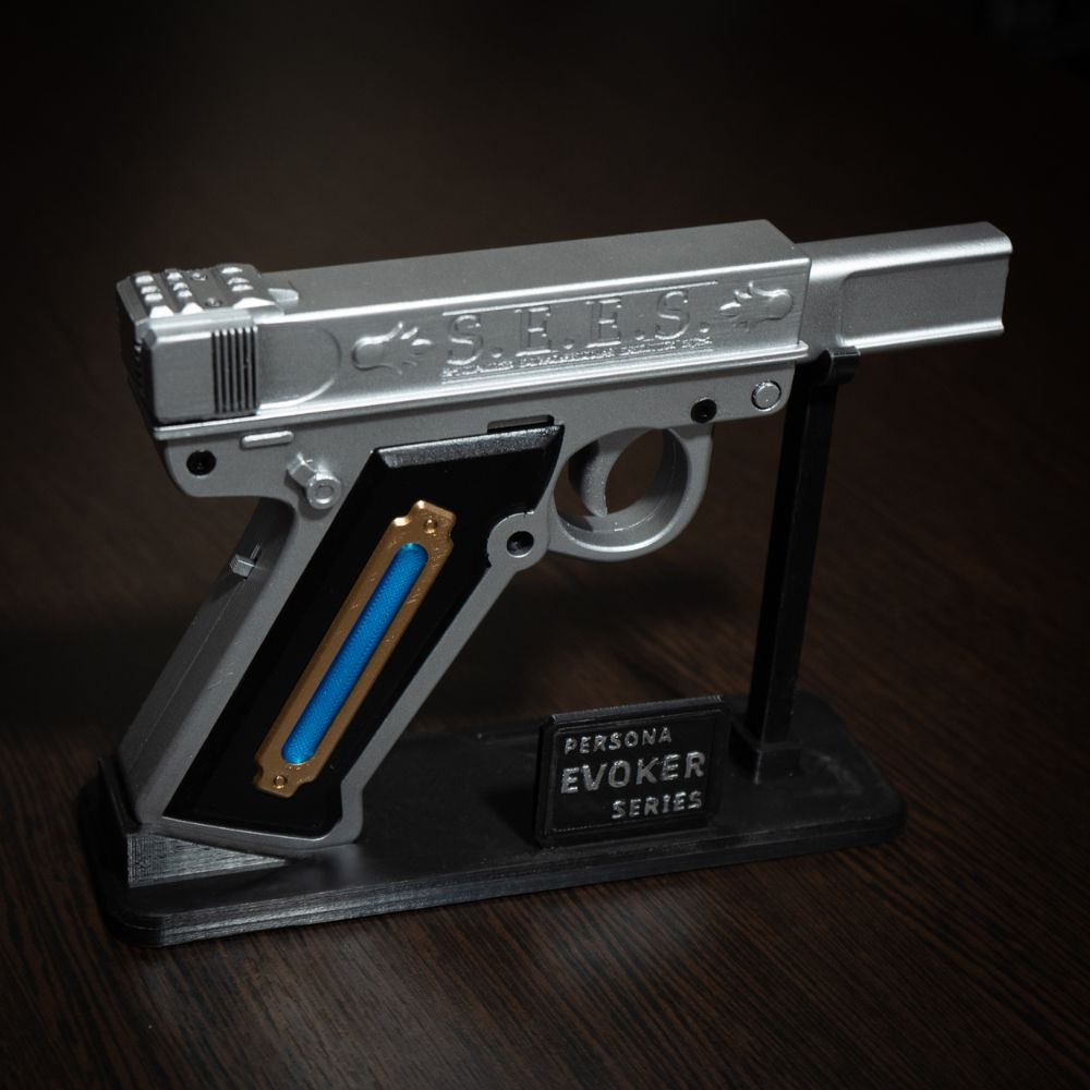 Metallic gun-shaped object with 'S.E.E.S.' branding on a dark background