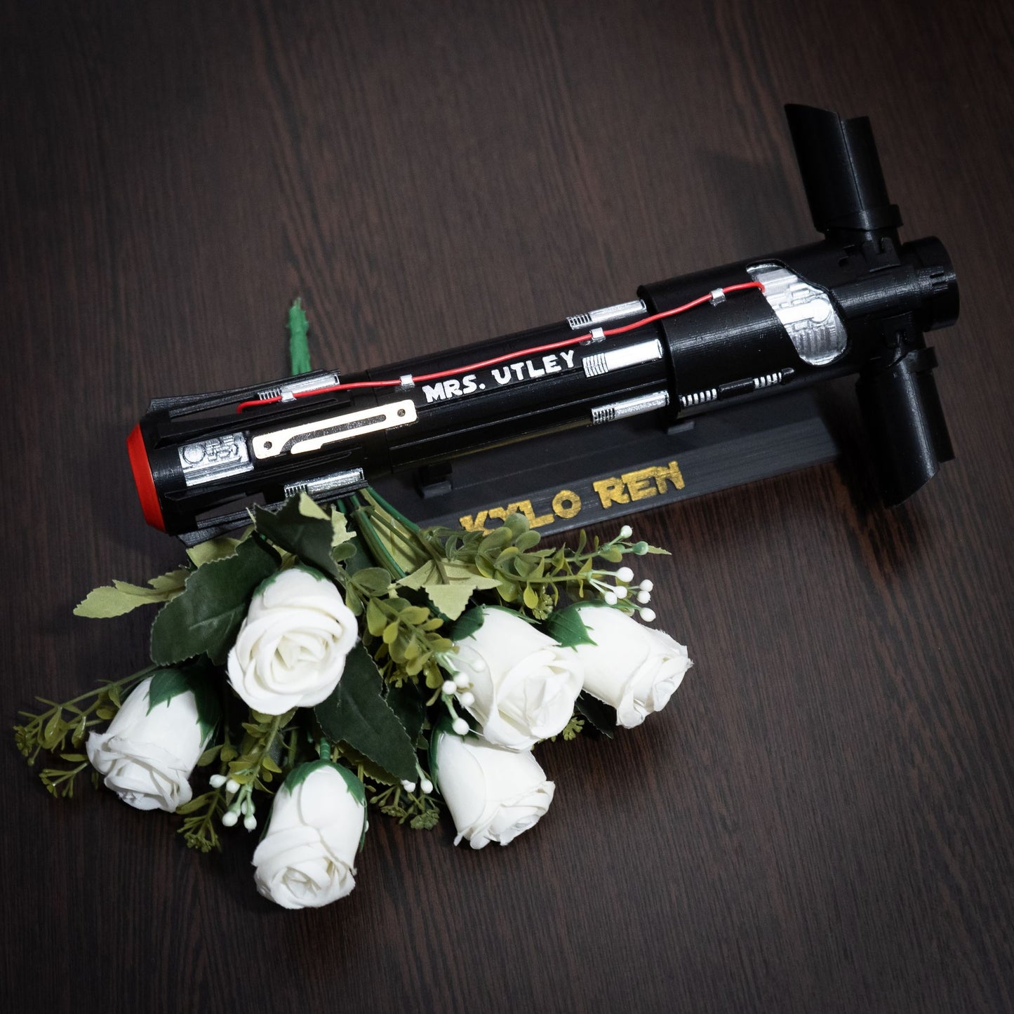 Bridal bouquet featuring red roses held in a 3D printed Kylo Ren lightsaber hilt