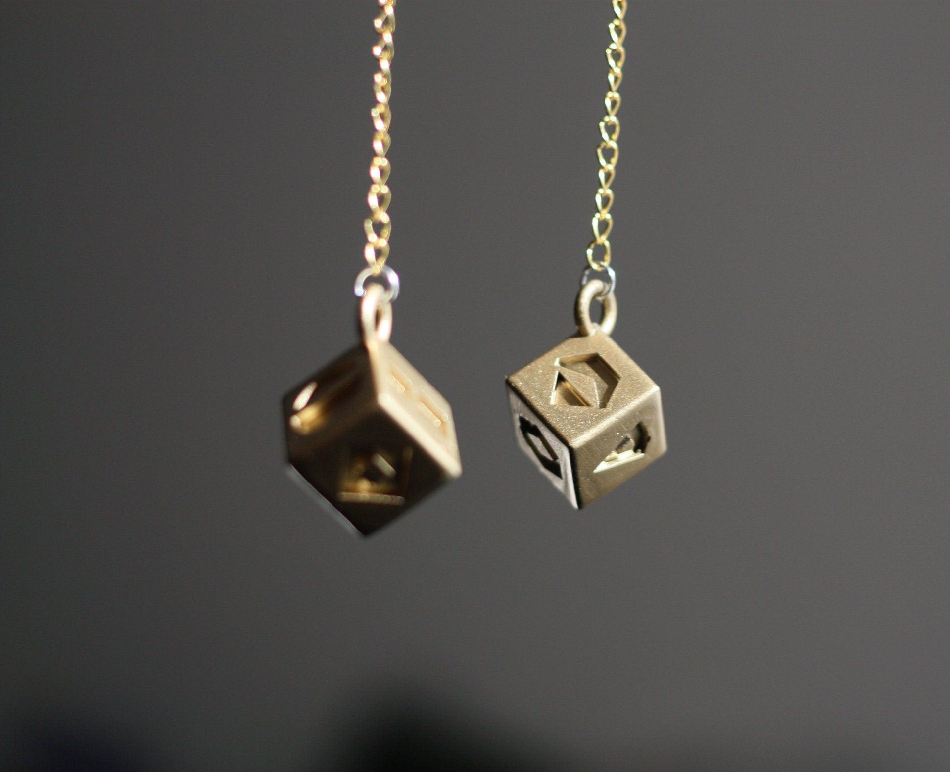 Han Solo's golden lucky dice replica hanging on gold chains for Star Wars cosplay accessory
