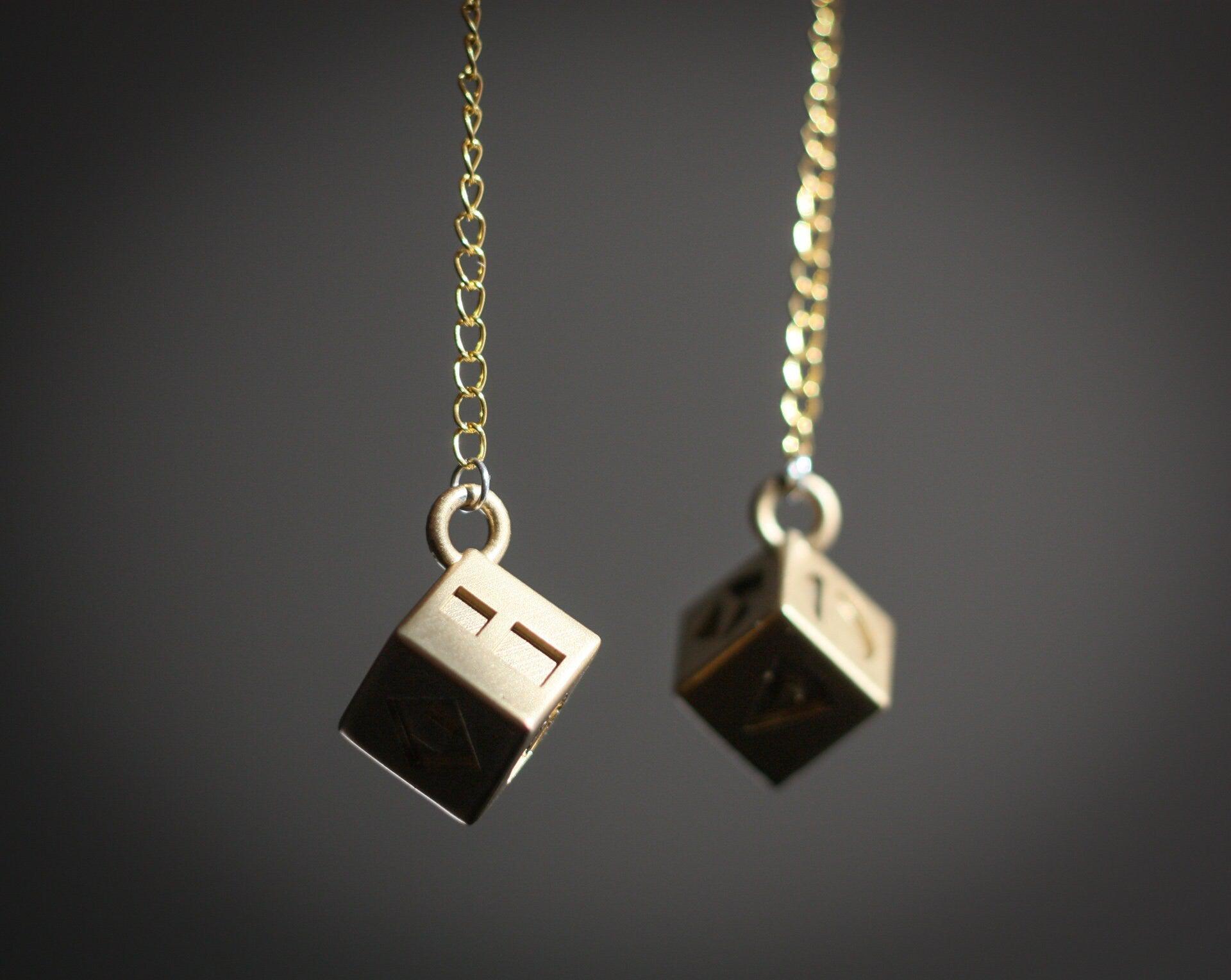 Han Solo's golden lucky dice replica on gold chains for Star Wars cosplay accessory