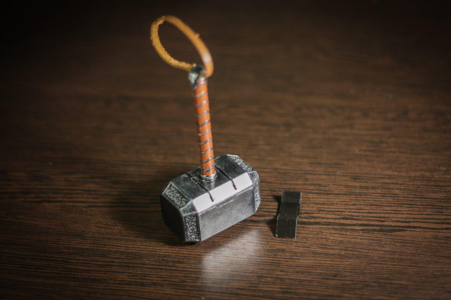 1:4 scale miniature Thor hammer replica with leather-wrapped handle and display stand on wooden surface