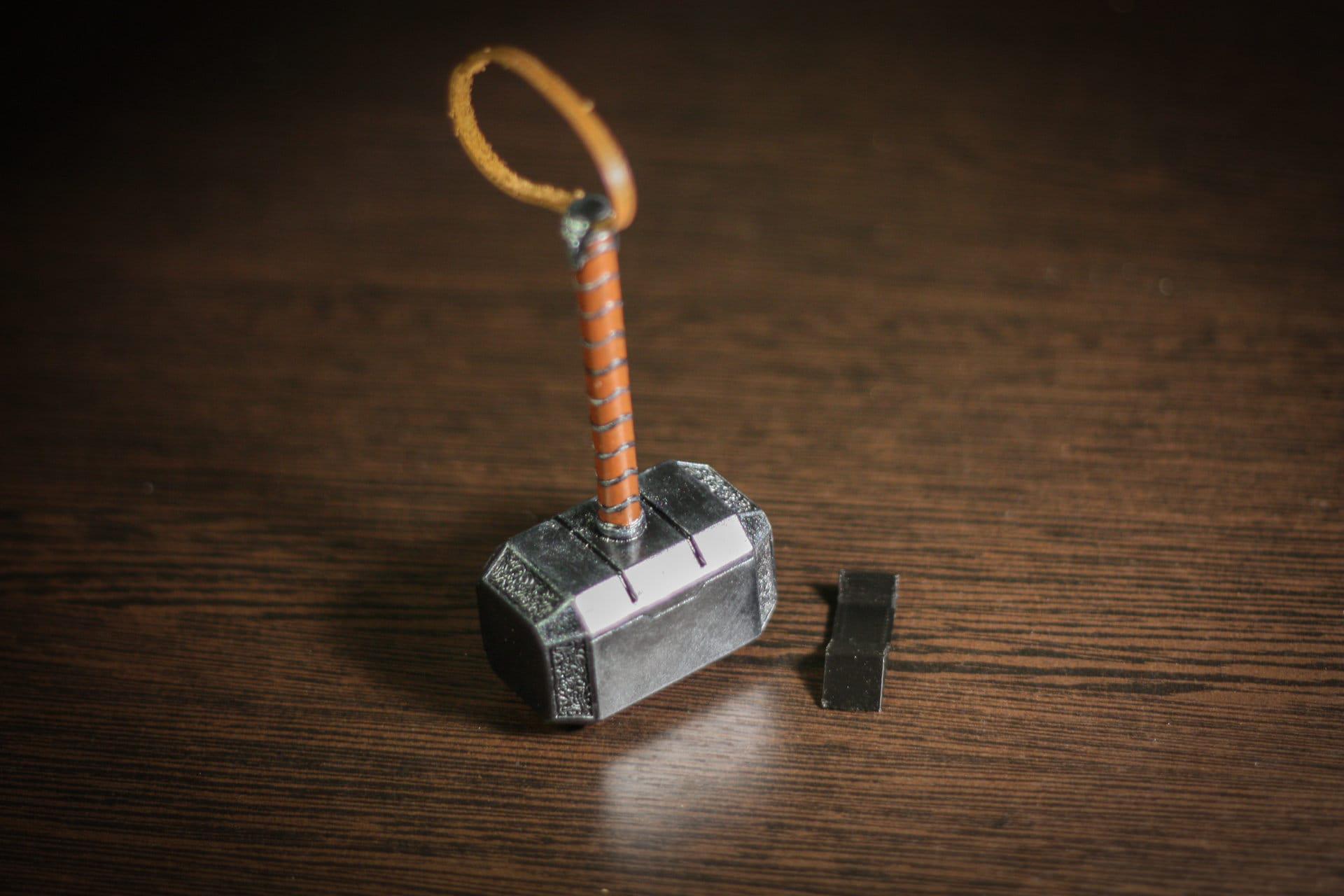 1:4 scale miniature Thor hammer replica with leather-wrapped handle and display stand on wooden surface